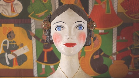 A handcrafted depiction of a woman's head. Select to go to an excerpt from Alexander Girard's 1968 essay on folk art.