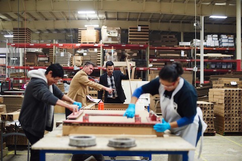 Two men and two women on the plant floor at Eagle Packaging.