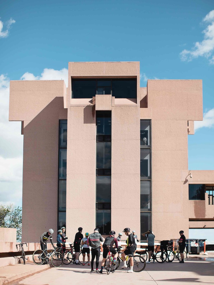 Dismounted bicyclists interact outside Boulder's Mesa Laboratory, designed by modernist architect I.M. Pei.