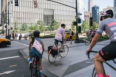 Bicyclists pedal around the corner at the intersection of West and Vesey streets in Manhattan.
