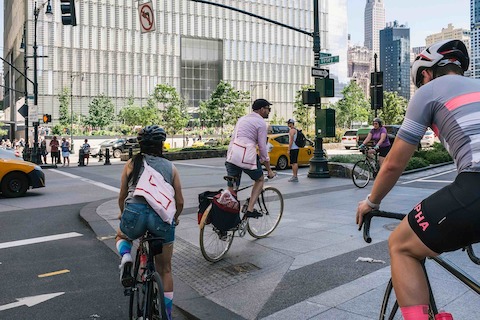 Bicyclists pedal around the corner at the intersection of West and Vesey streets in Manhattan. Bicyclists pedal around the corner at the intersection of West and Vesey streets in Manhattan.