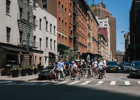 Bicyclists stop at the intersection of a residential street in Manhattan.
