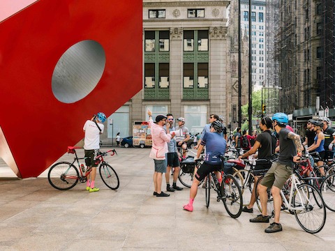 Bicyclists examine Isamu Noguchi's Red Cube sculpture in New York.