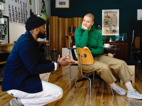Jared Blake talking with a friend about the Eames Molded Plywood Dining Chair. 