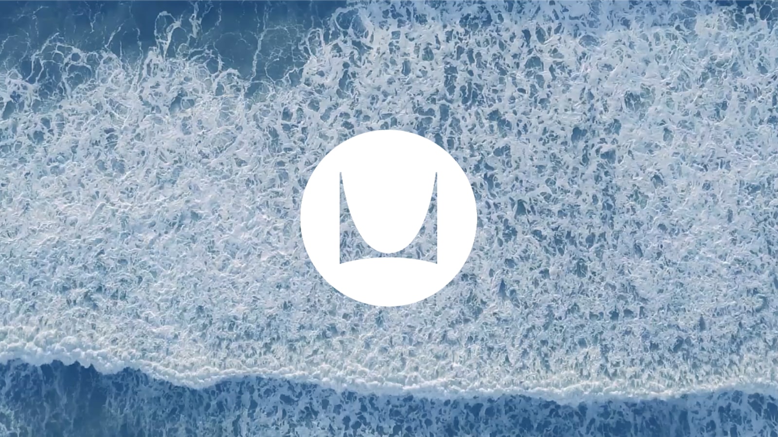 An aerial view of ocean waves, with an animated Herman Miller logo.