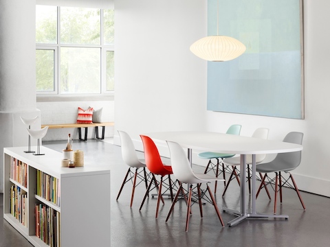 An open meeting area featuring an oval Everywhere Table and Eames Molded Plastic Chairs in various colours.