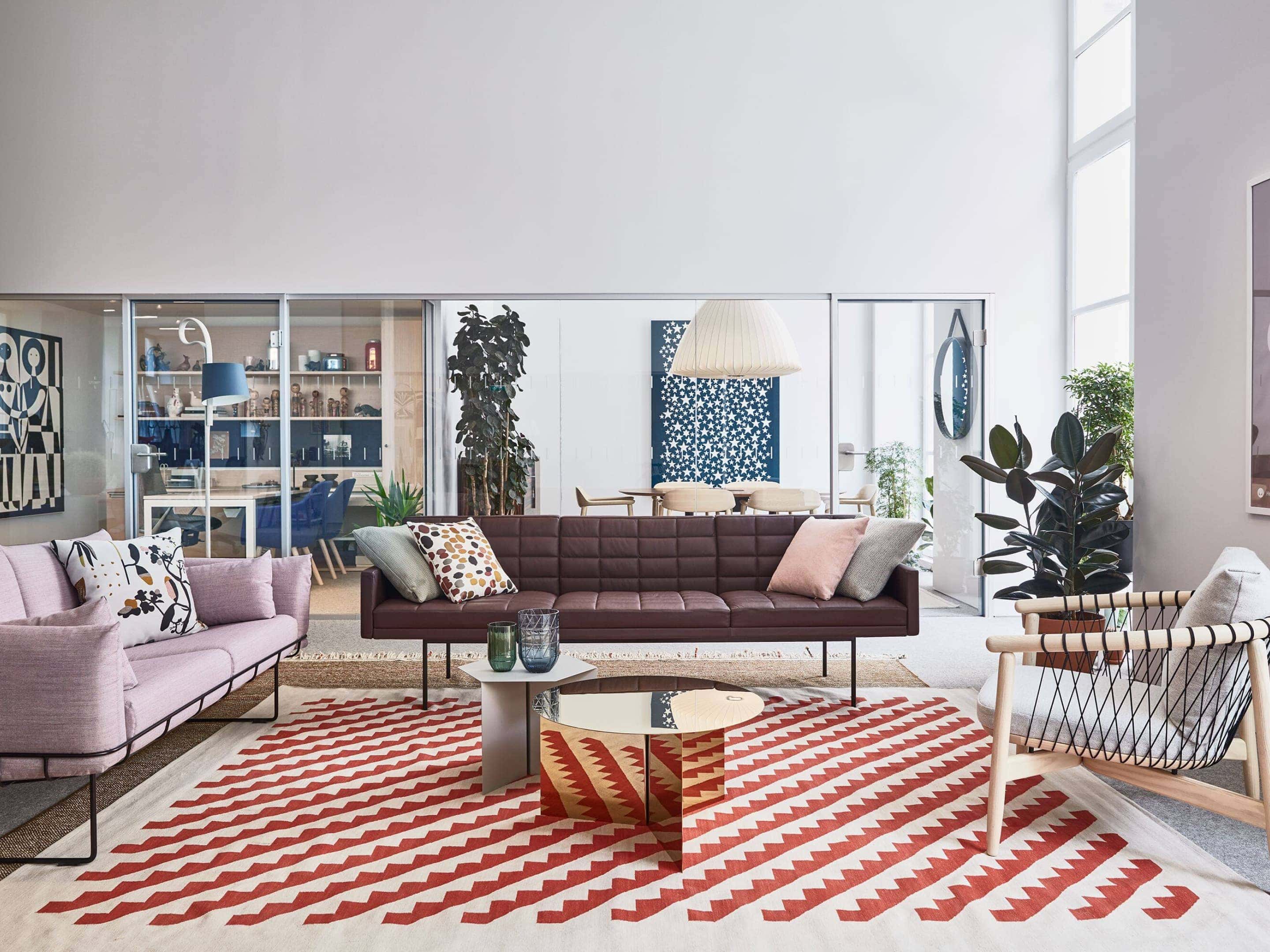 Configuração de lounge no showroom de Paris, apresentando sofás Wireframe e Tuxedo e uma cadeira Crosshatch em madeira.