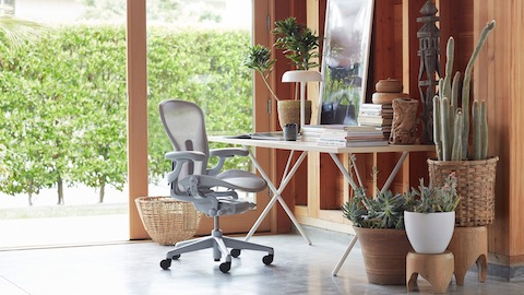 Een Aeron-stoel en een Nelson QQX-beentafel in een thuiskantoor. Selecteer om naar de Herman Miller-winkel en andere online winkels te gaan.